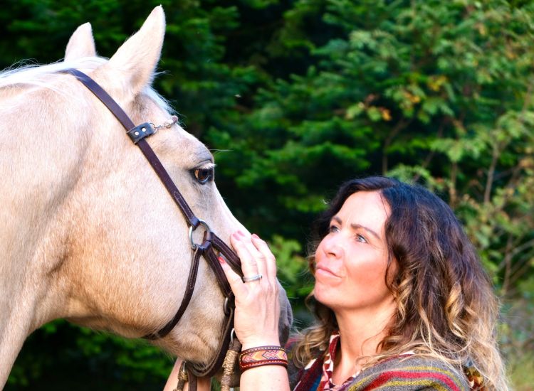 Tierkommunikatorin schaut ihrem Pferd tief und verbunden in die Augen.